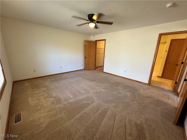 carpeted empty room with a textured ceiling and ceiling fan