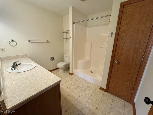 bathroom with toilet, vanity, a shower, and tile patterned flooring