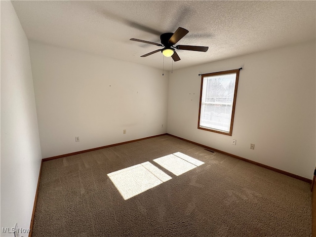 carpeted spare room with a textured ceiling and ceiling fan