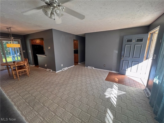 living room featuring ceiling fan and a textured ceiling