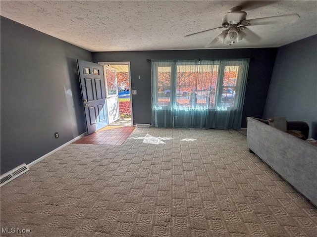 unfurnished living room with carpet flooring, ceiling fan, and a textured ceiling