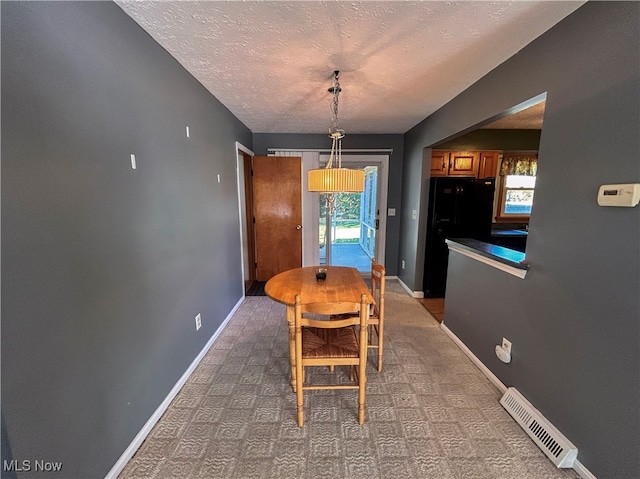 dining space featuring a textured ceiling