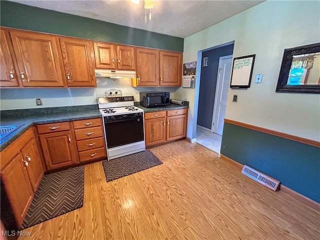 kitchen featuring white range oven and light wood-type flooring