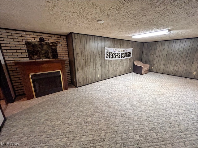 basement with carpet, a textured ceiling, and wooden walls