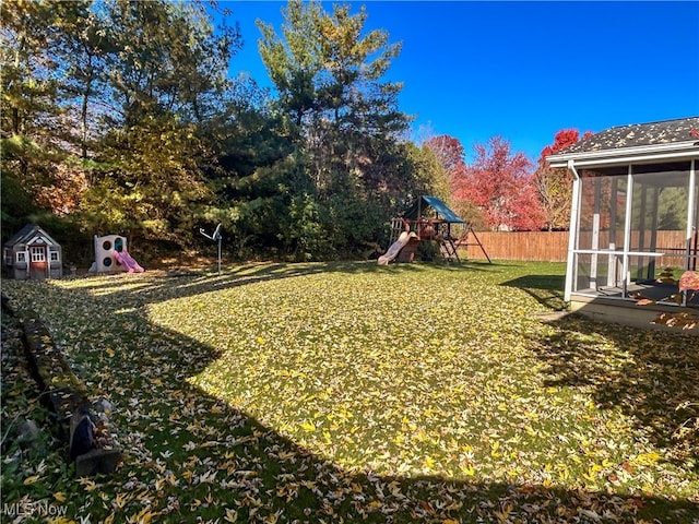 view of yard featuring a sunroom and a playground