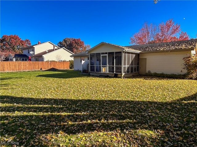 back of house featuring a sunroom and a yard