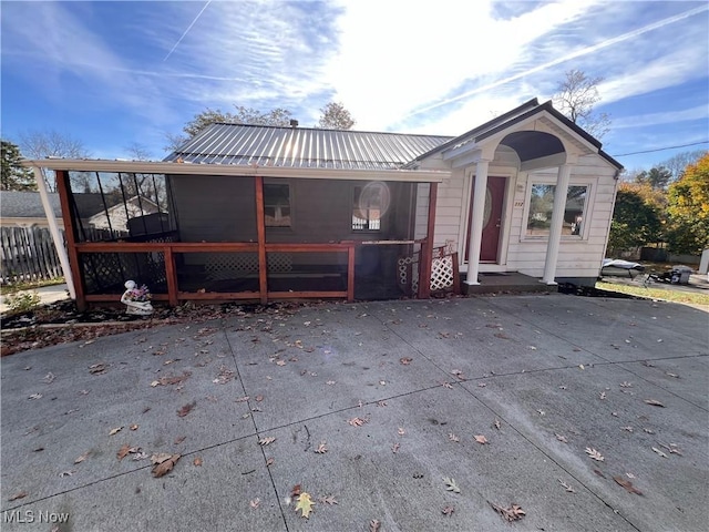 rear view of house featuring a sunroom