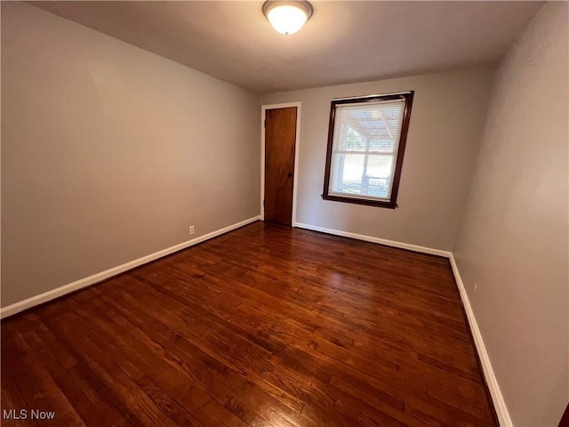 unfurnished room with dark wood-type flooring