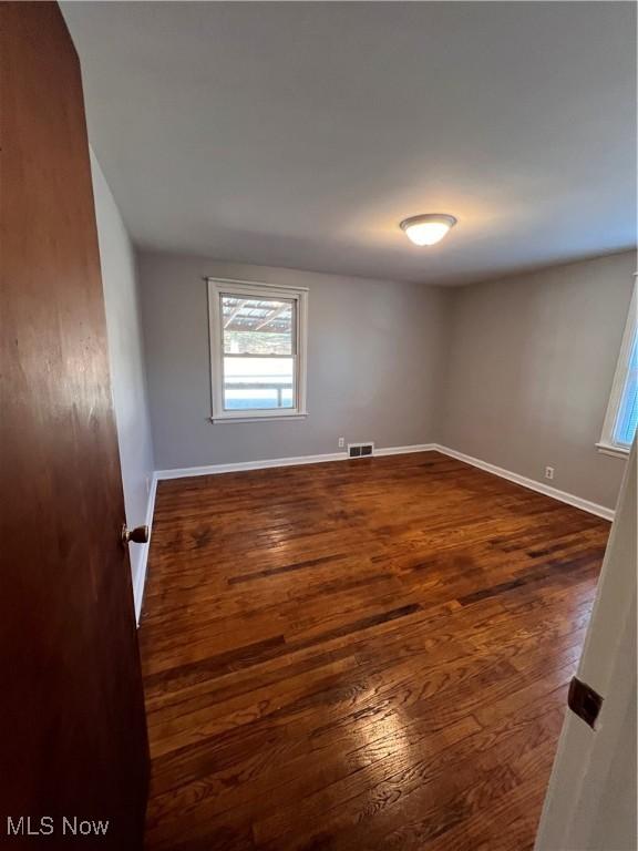 unfurnished room with dark hardwood / wood-style floors