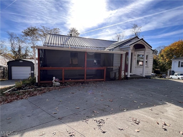 view of front of property featuring an outbuilding, a garage, and a sunroom