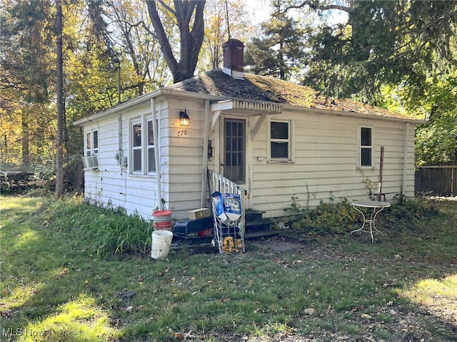 back of property with a lawn and cooling unit