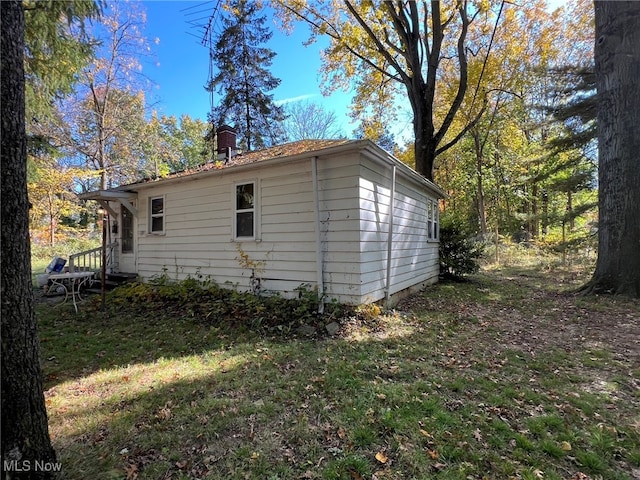 view of side of home with a yard