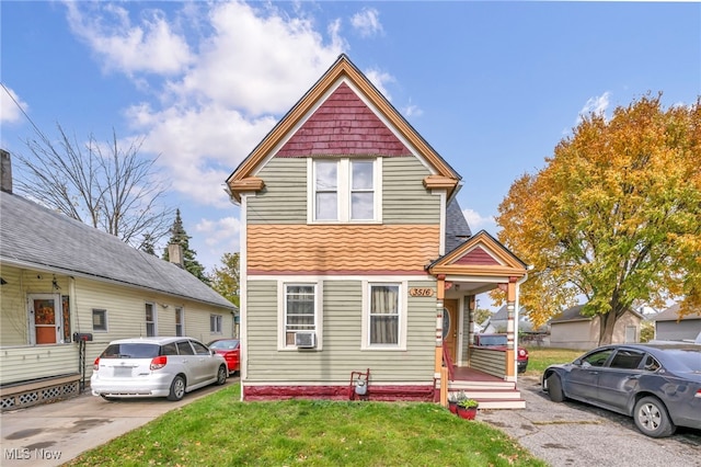 view of front facade with cooling unit and a front yard