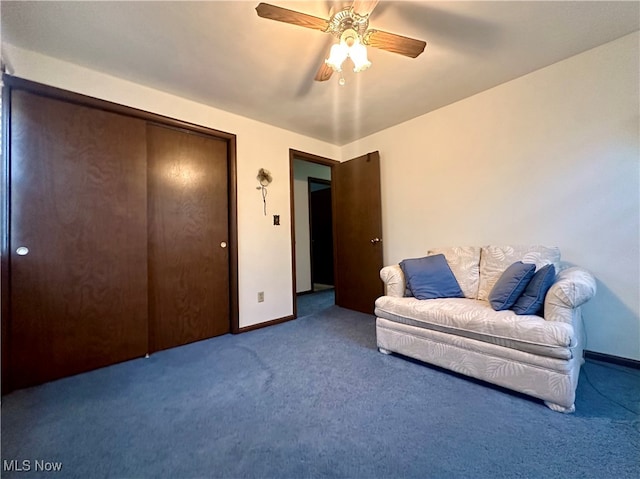 sitting room featuring dark colored carpet and ceiling fan