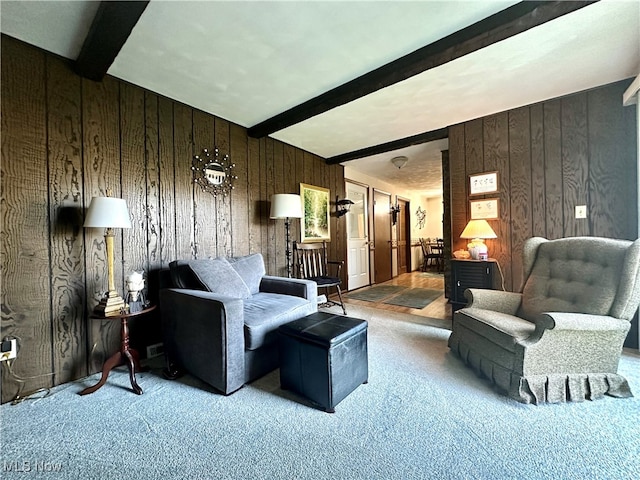 carpeted living room with beam ceiling and wooden walls