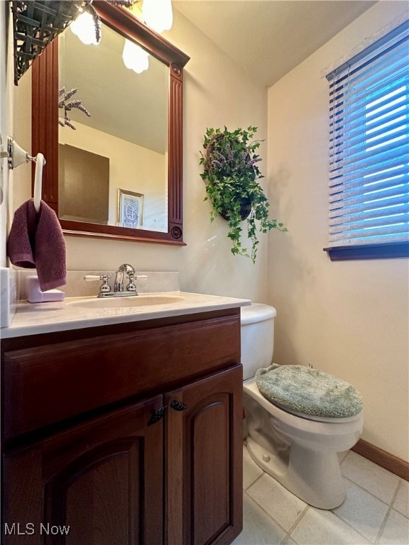 bathroom featuring toilet, vanity, and tile patterned flooring