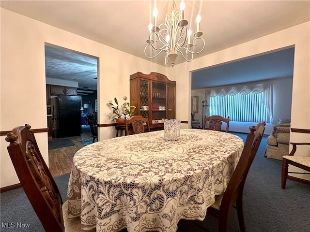 dining room with a chandelier and dark carpet