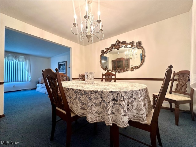 carpeted dining room featuring a chandelier