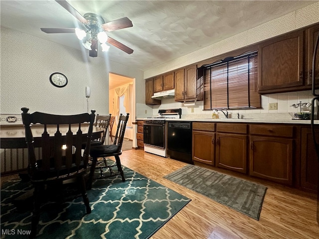 kitchen featuring ceiling fan, black dishwasher, light hardwood / wood-style flooring, and gas range gas stove