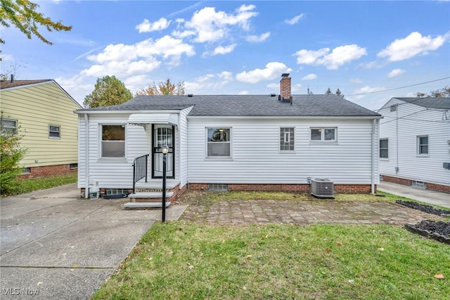 exterior space featuring central air condition unit, a patio area, and a front yard