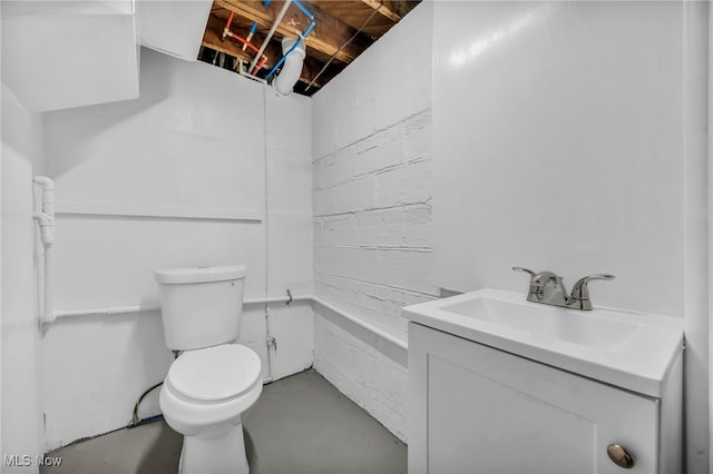 bathroom featuring toilet, concrete floors, vanity, and a shower