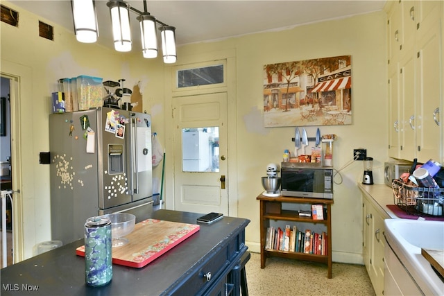 kitchen featuring appliances with stainless steel finishes, white cabinets, and pendant lighting