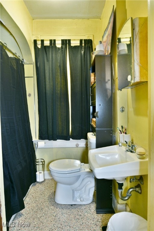 full bathroom featuring toilet, sink, and shower / tub combo