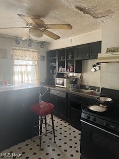 kitchen with a kitchen breakfast bar, a textured ceiling, electric range, and ceiling fan