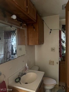 bathroom with vanity, toilet, and a shower with curtain