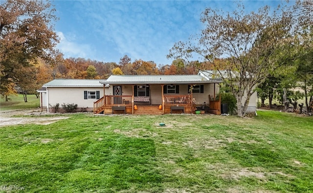 rear view of property featuring a porch and a lawn