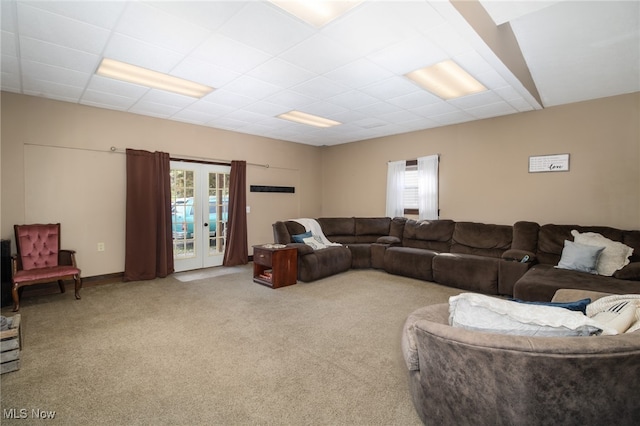 living room featuring a wealth of natural light, french doors, and carpet