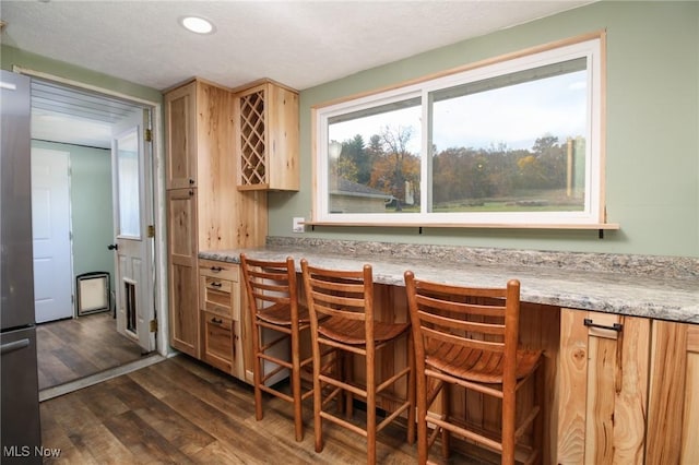 5057 Buchanan Rd, Waterford, OH 45786 - kitchen featuring a breakfast bar area, a textured ceiling, dark wood-style floors, light brown cabinets, and recessed lighting