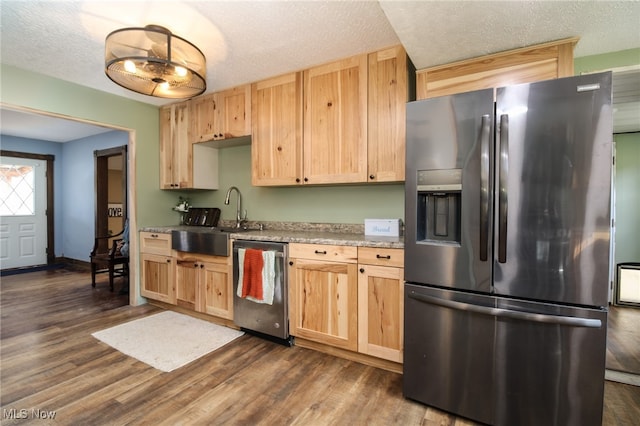 kitchen with sink, appliances with stainless steel finishes, dark hardwood / wood-style floors, and a textured ceiling