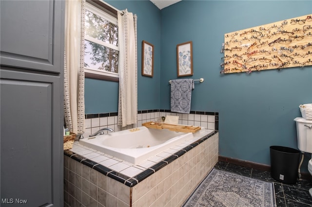 bathroom featuring toilet and tiled tub