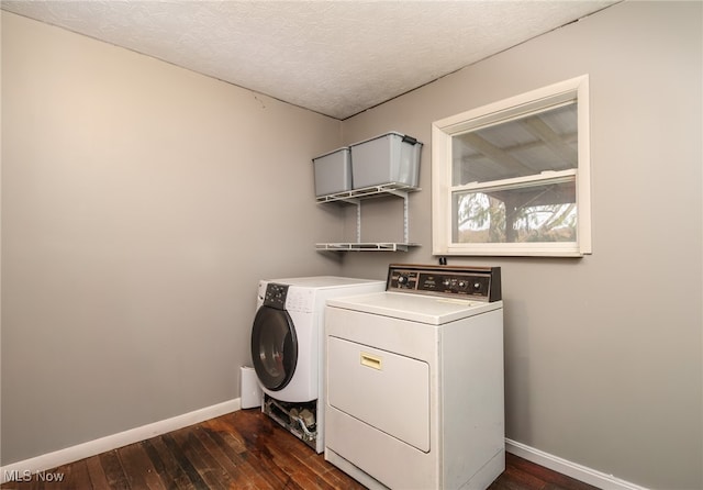 clothes washing area with washer and dryer, a textured ceiling, and dark wood-type flooring