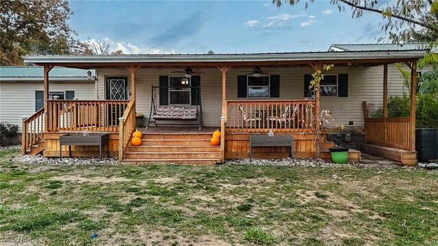 rear view of house featuring covered porch and a lawn