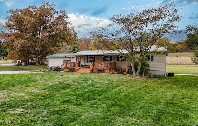 back of property featuring a deck and a lawn