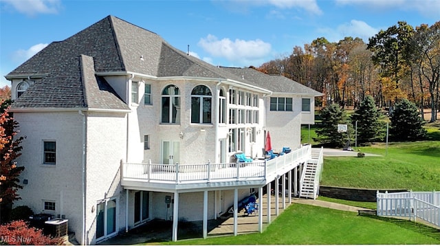 rear view of house featuring a wooden deck and a lawn