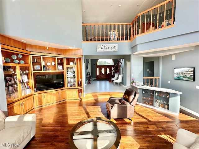 living room with hardwood / wood-style floors and a high ceiling