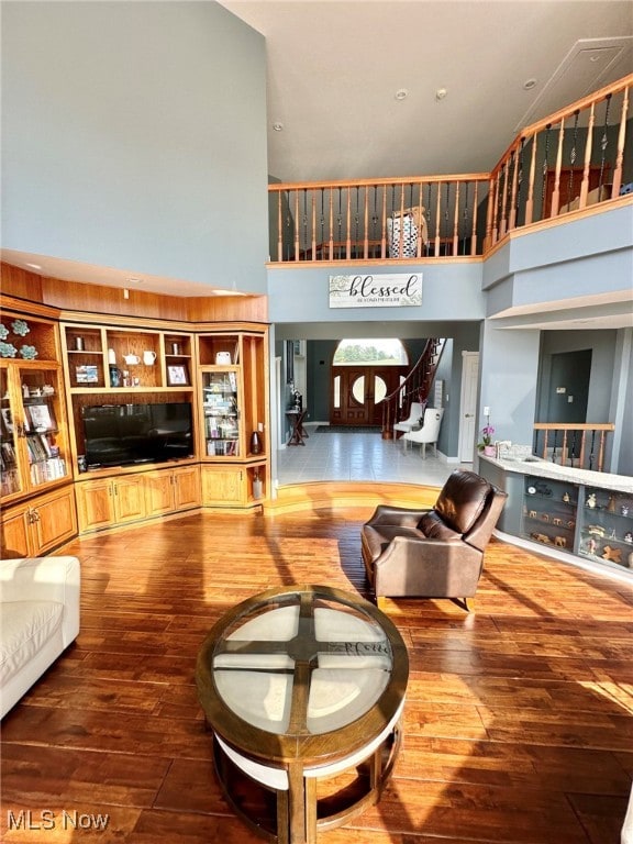 living room with a towering ceiling and hardwood / wood-style floors