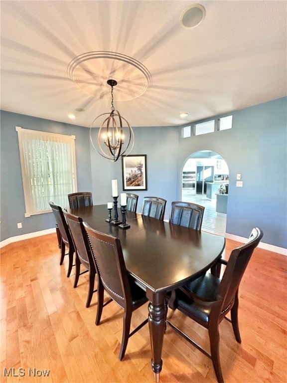 dining area with light hardwood / wood-style floors and a chandelier