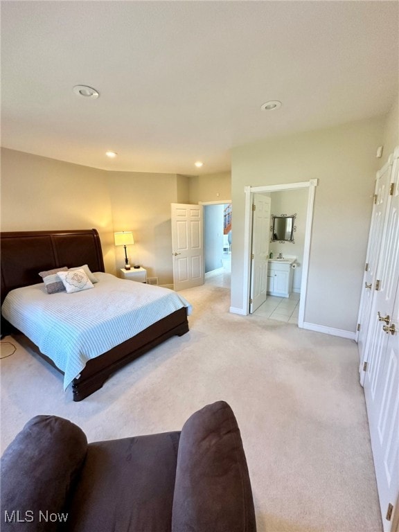 bedroom with light carpet and ensuite bathroom