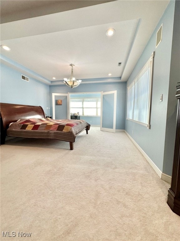 bedroom with light carpet and an inviting chandelier