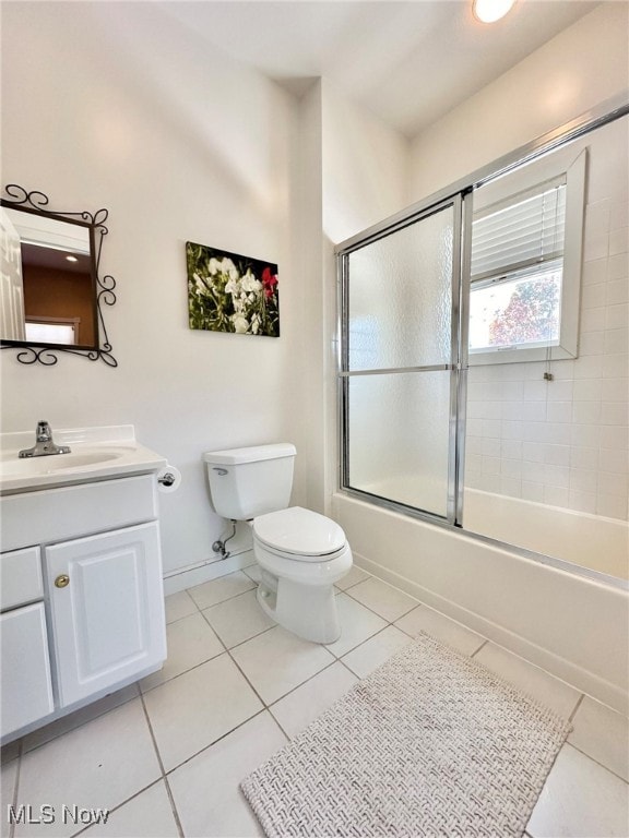 full bathroom featuring vanity, toilet, tile patterned floors, and enclosed tub / shower combo