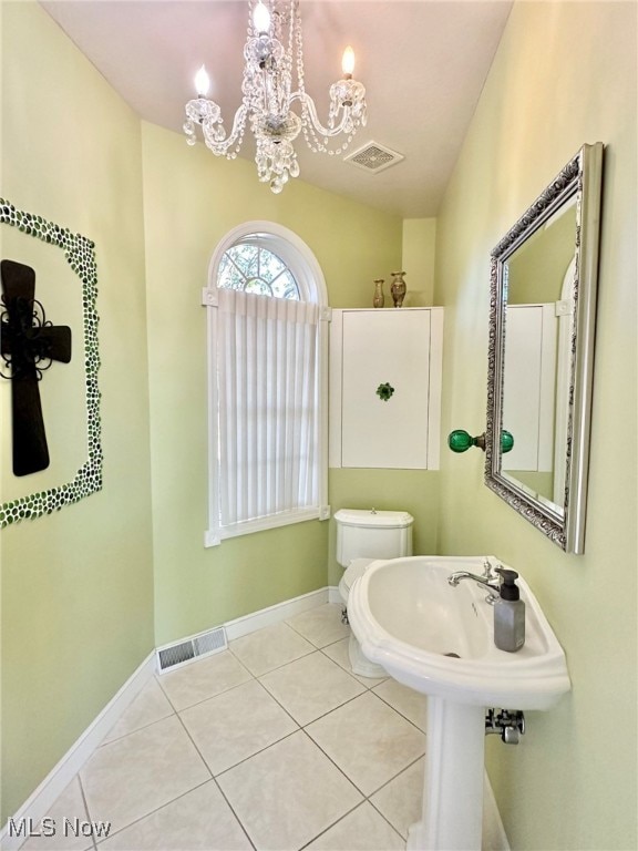 bathroom featuring toilet, lofted ceiling, an inviting chandelier, and tile patterned flooring