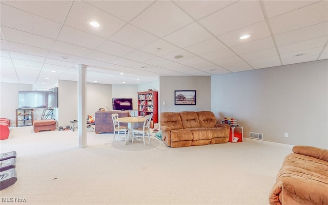 living room featuring carpet and a drop ceiling