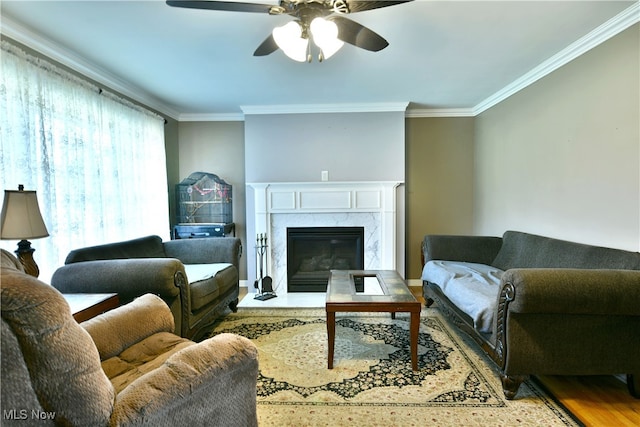 living room featuring crown molding, hardwood / wood-style floors, a high end fireplace, and ceiling fan