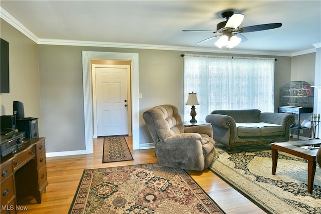 living room with crown molding, light hardwood / wood-style flooring, and ceiling fan