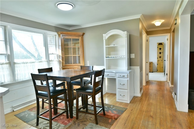 dining area with crown molding and light wood-type flooring