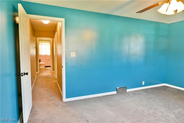 carpeted spare room featuring ceiling fan